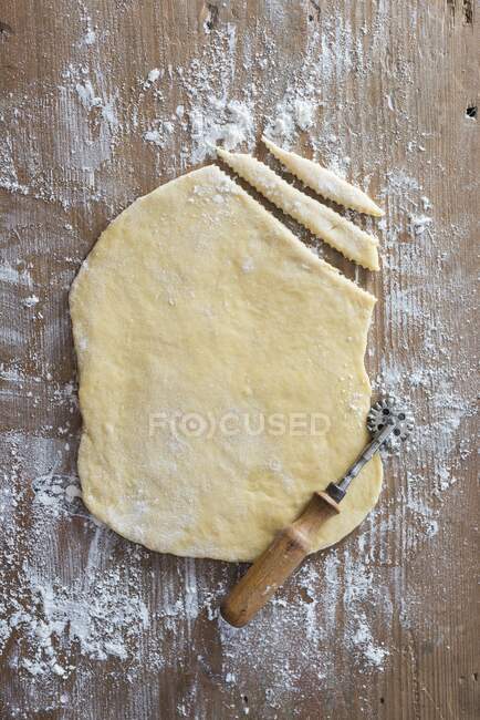 Rolled-out pastry on a wooden board — Stock Photo