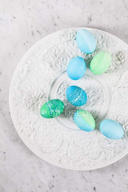 Фарбовані великодні яйця з візерунками батика на керамічній тарілці — стокове фото