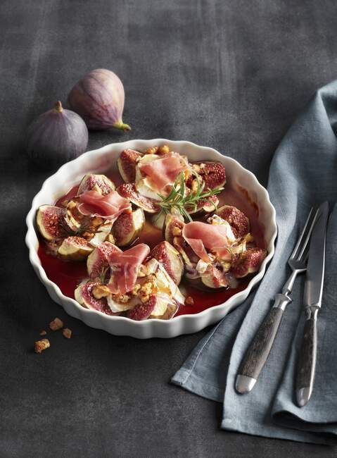 Figs baked with goat's cheese, and raw ham — Stock Photo