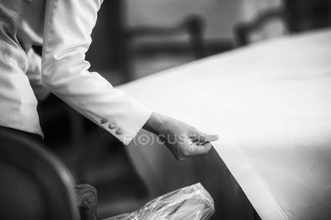 Официант тянет скатерть над столом ресторана — стоковое фото