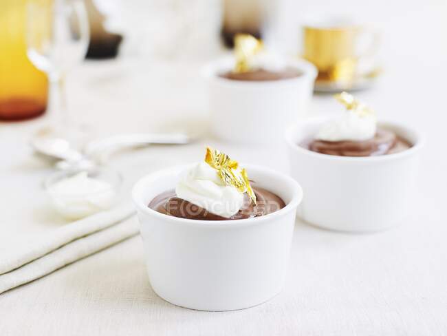 Chocolate cream pudding with sour cream and gold leaf — Stock Photo