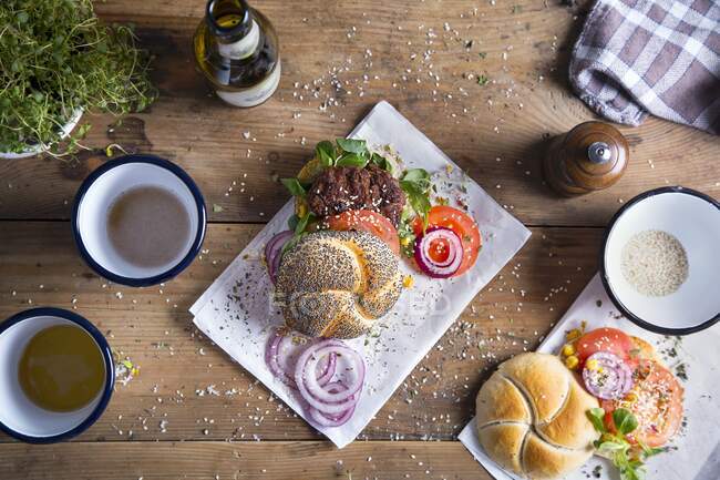 Hamburguesa con pan de amapola, tomates frescos, cebolla y semillas de sésamo - foto de stock