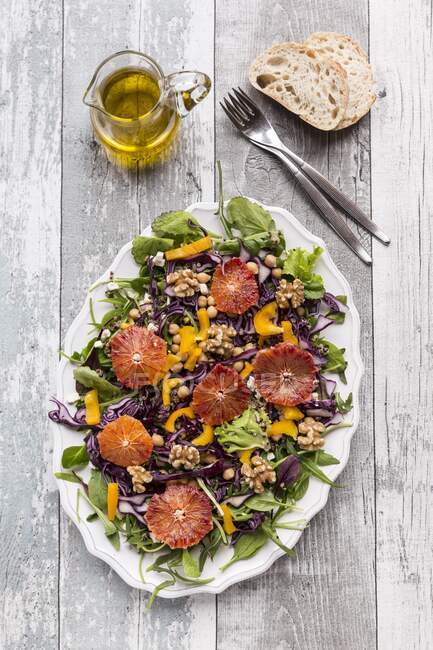 Plateau de salade avec quinoa, pois chiches, poivron jaune, noix, chou rouge et orange sanguine — Photo de stock