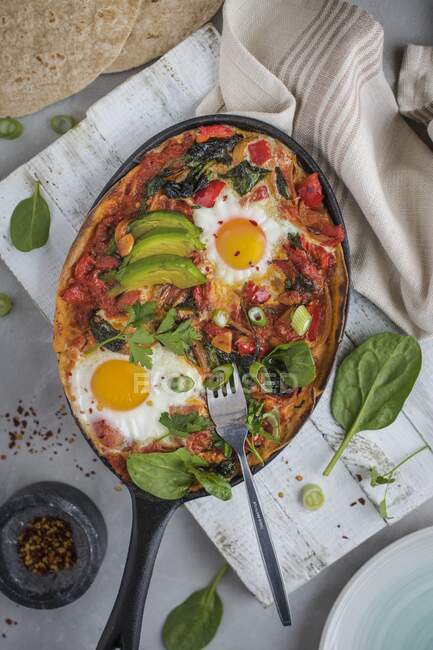 Huevos rancheros, mexikanische Tortilla, Tomaten, Paprika und Chili gebackene Eier mit Avocado — Stockfoto