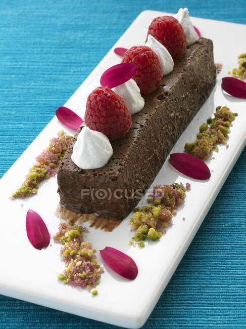 Un marqués de chocolate entero con frambuesas y postre gourmet crema - foto de stock