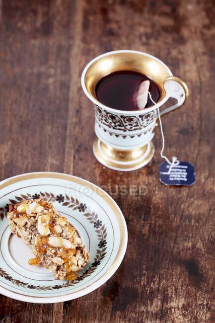 Müsliriegel mit Erdnüssen und gesalzenem Karamell, dazu eine Tasse Tee — Stockfoto
