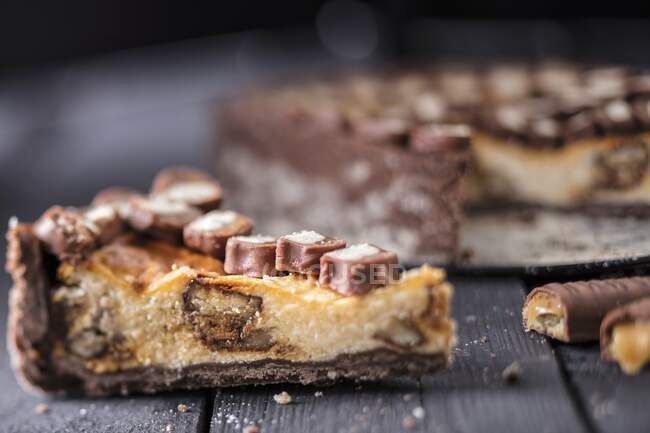 Cheesecake with chocolate and caramel biscuit bars — Stock Photo