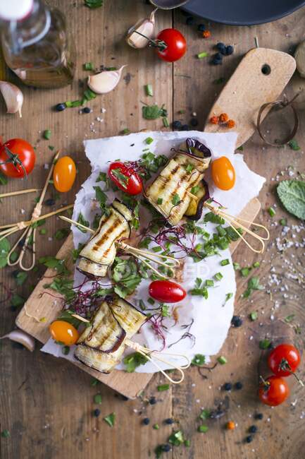 Grilled Aubergines with tomatoes and chives on cutting board — Stock Photo