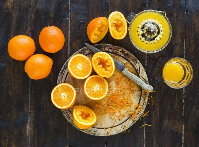 Naranjas frescas - algunas exprimidas para hacer jugo de naranja fresco - foto de stock