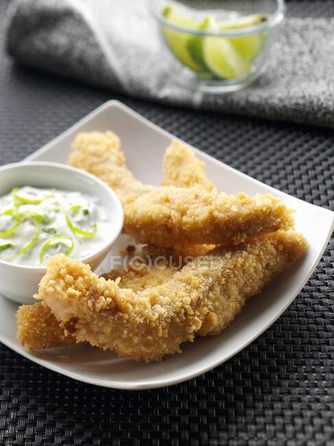 A plate of salmon goujons with dipping sauce — Stock Photo