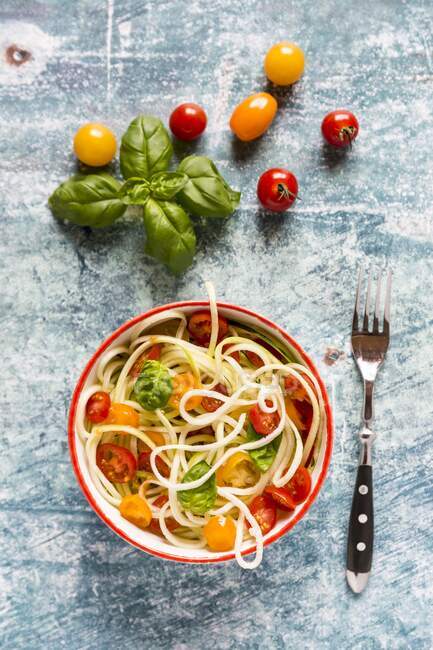 Zoodles (zucchini noodles) with tomatoes and basil — Stock Photo