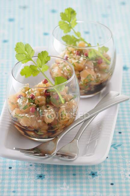 Tartar de salmón con jengibre, granos de pimienta rosa y cilantro - foto de stock