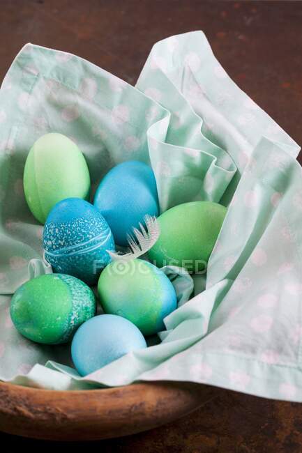 Dyed Easter eggs with batik patterns on a cloth in a basket — Stock Photo