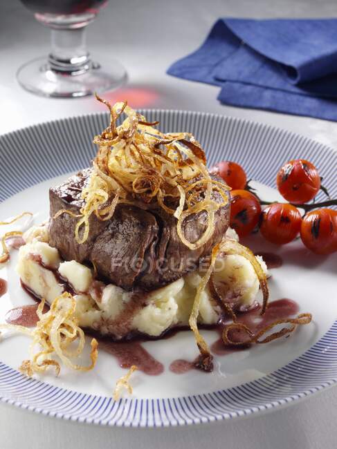 Fillet steak with tomatoes, mashed potato, caramelized onions and balsamic vinegar — Stock Photo