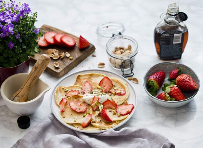 Pancakes with strawberries and pistachios — Stock Photo
