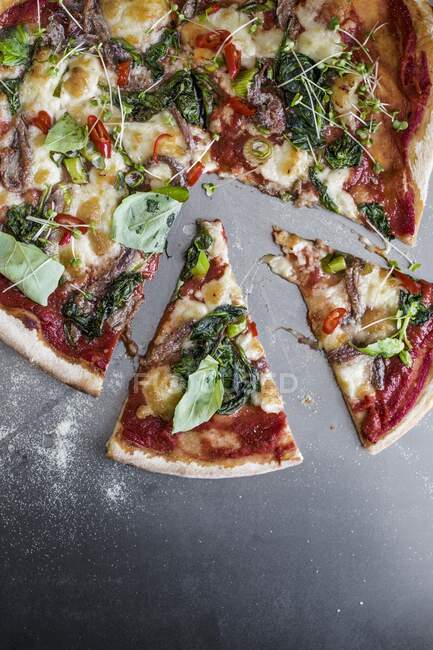 Pizza casera con anchoas y espinacas, de cerca - foto de stock