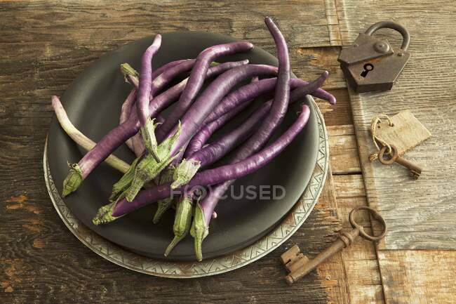 Long, thin aubergines on a plate — Stock Photo