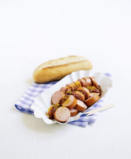 Sausages with curry, ketchup and bread rolls — Stock Photo