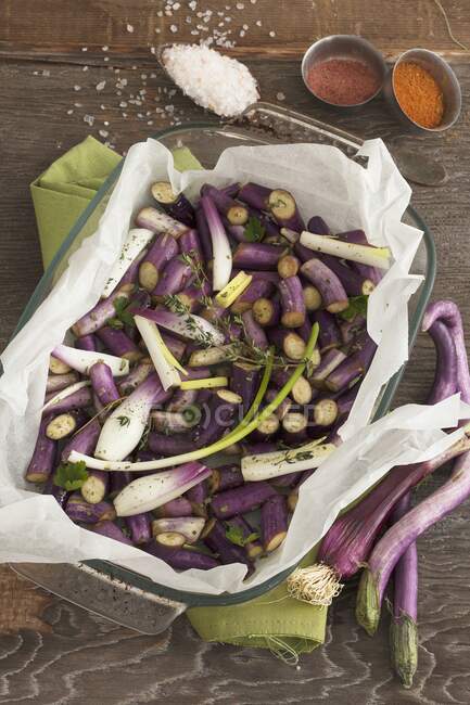 Chopped long, thin aubergines and spring onions in parchment paper — Stock Photo