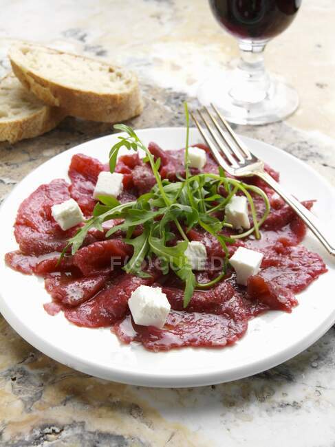A plate of beef carpaccio with goats cheese — Stock Photo