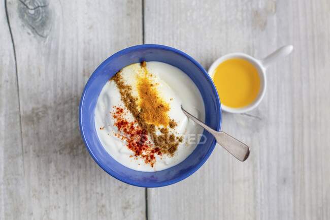 Yoghurt with cinnamon, chilli, turmeric and flaxseed oil — Stock Photo