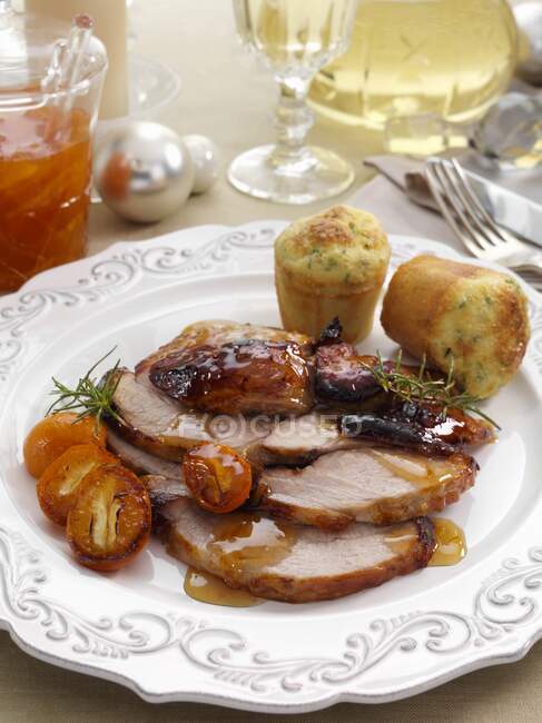 Individual portion of leg of pork slices with kumquat marmalade glaze and cheese chive muffins main meals — Stock Photo