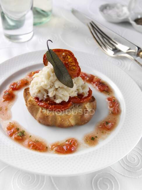 Brandade of salted cod on a slice of brioche in a restaurant table setting — Stock Photo