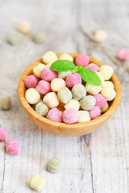 Small colourful gnocchi with basil leaves — Stock Photo