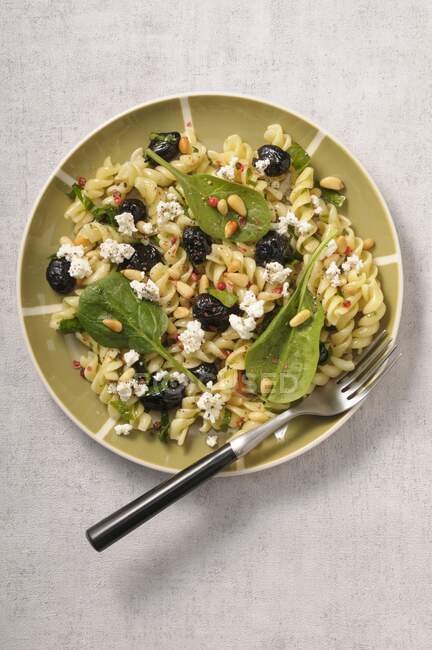 Fusilli mit Spinat, Oliven, Feta und Pinienkernen — Stockfoto