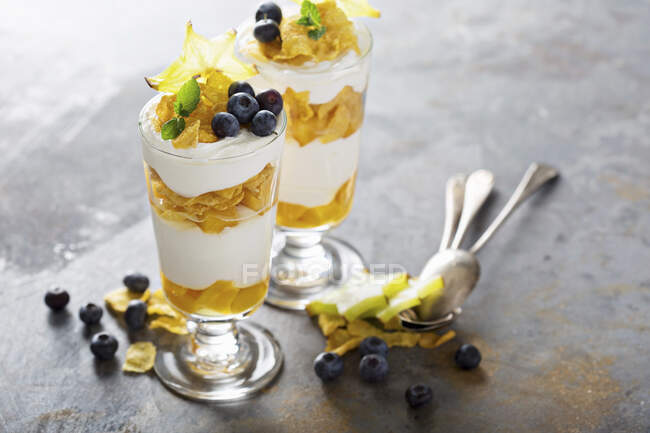 Yoghurt cereal parfait with mango and tropical fruit, layered desserts — Stock Photo