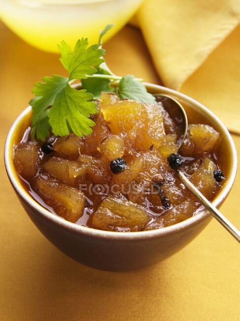 A bowl of pinapple chutney on a yellow background — Stock Photo