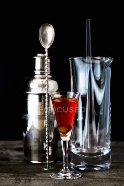 A glass of homemade cherry brandy with bar utensils — Stock Photo