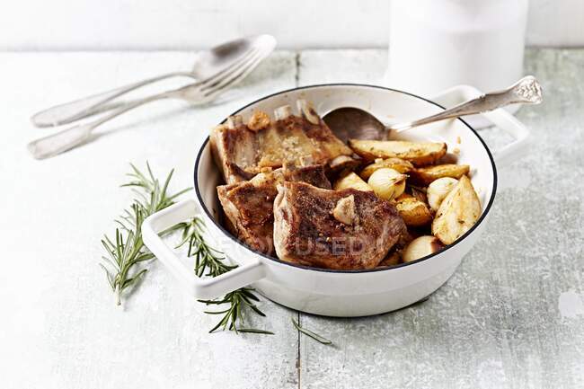 Lamb ribs with baked potatoes and onions in a pot — Stock Photo