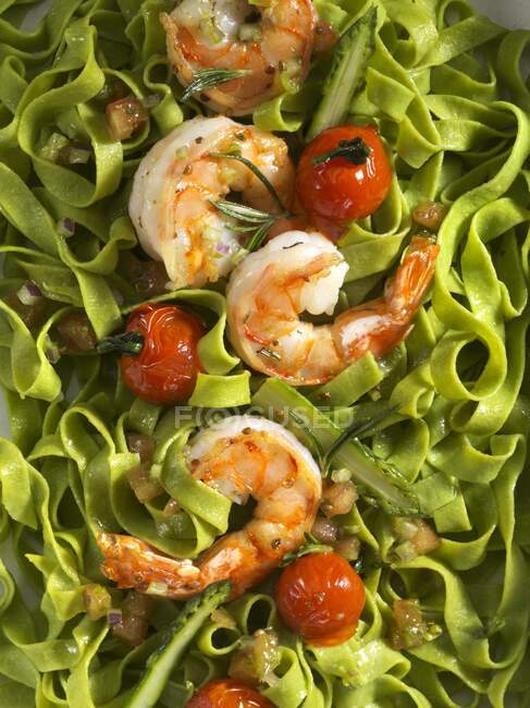 Green pasta with prawns and cocktail tomatoes — Stock Photo