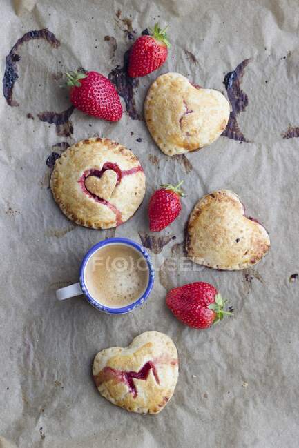 Tartes à la main (mini tartes) avec garniture aux fraises et décorations coeur — Photo de stock