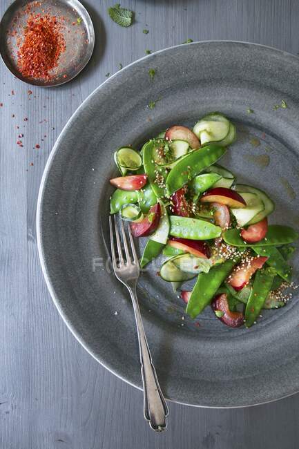 Sugar snap salad with plums and spices — Stock Photo