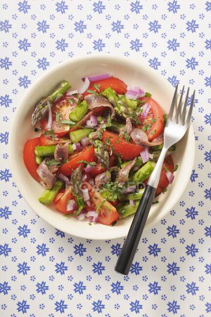 Salada de tomate com espargos verdes e anchovas — Fotografia de Stock