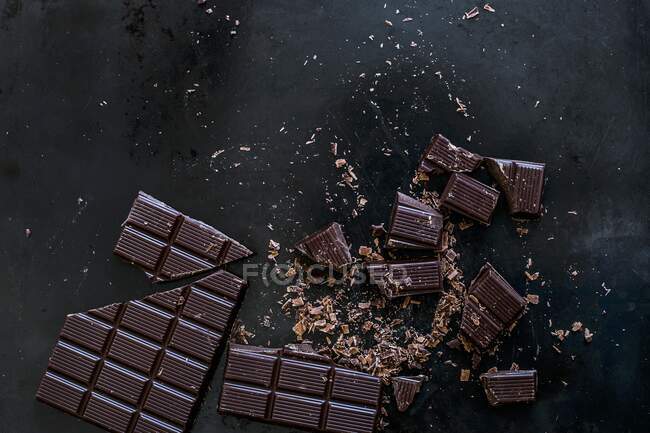 Whole and chopped squares of chocolate — Stock Photo