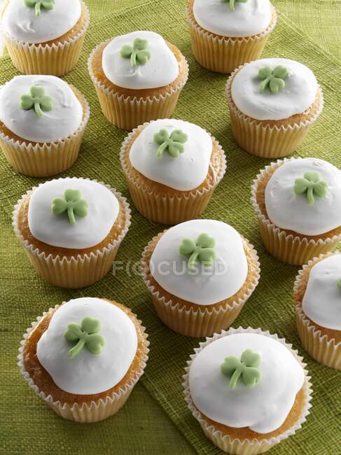 Cupcakes with green shamrock on top of white icing — Stock Photo