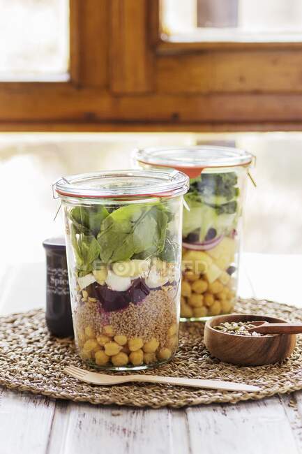 Duas saladas em jarros preparados em um serviço de buffet para um brunch com uma mistura de sementes para vestir — Fotografia de Stock