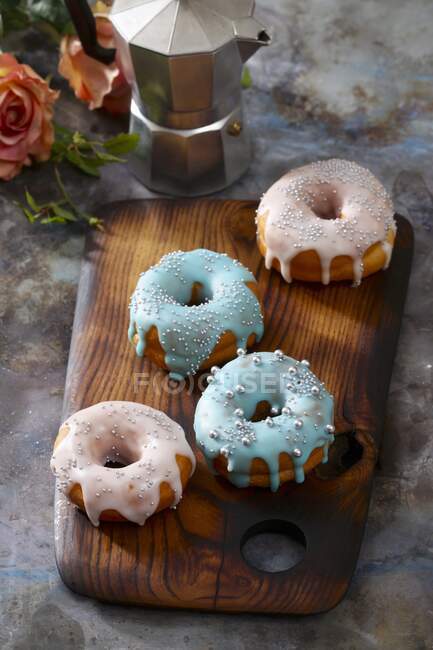 Doughnuts with colourful icing and silver sugar beads — Stock Photo