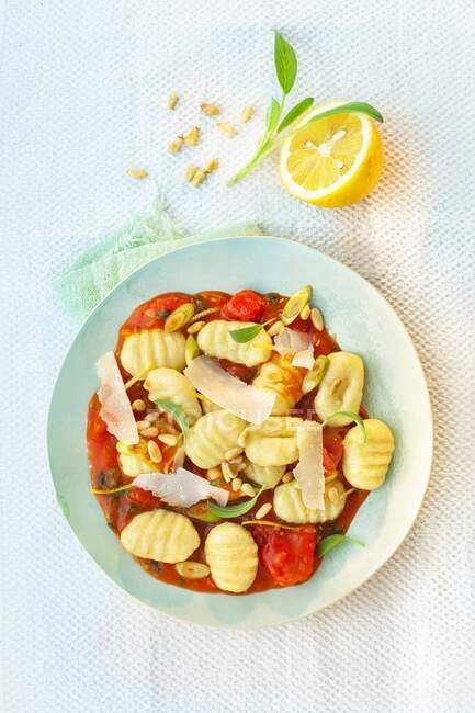 Gnocchi in tomato and lemon sauce with parmesan and pine nuts — Stock Photo
