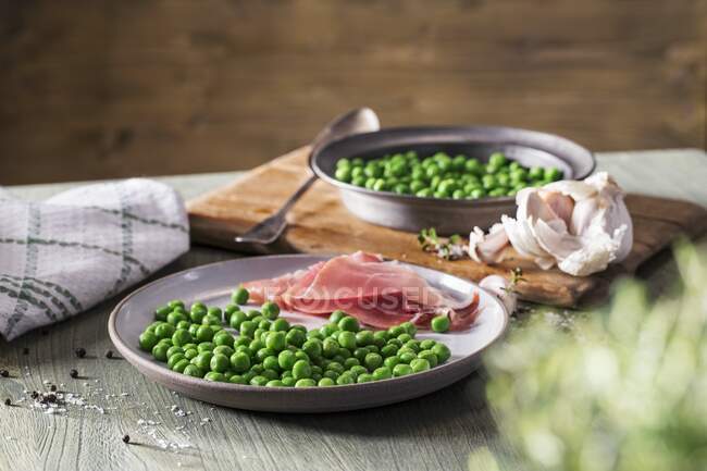 Peas with prosciutto close-up view — Stock Photo