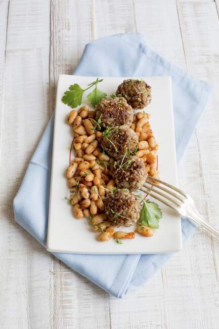 Meatballs on white beans with herbs — Stock Photo
