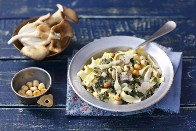 Tagliatelle with oyster mushrooms, spinach, cream and hazelnuts — Stock Photo