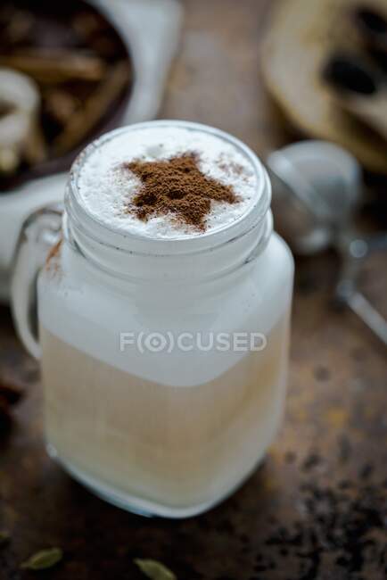 A chai latte decorated with a cocoa powder star — Stock Photo