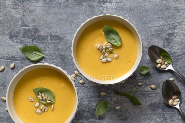 Pumpkin soup with roasted pumpkin seeds and basil — Stock Photo