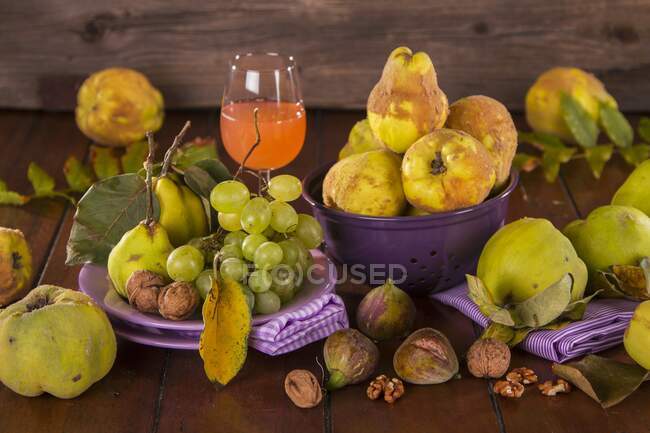 Still life with autumn fruits, quince juice and walnuts — Stock Photo