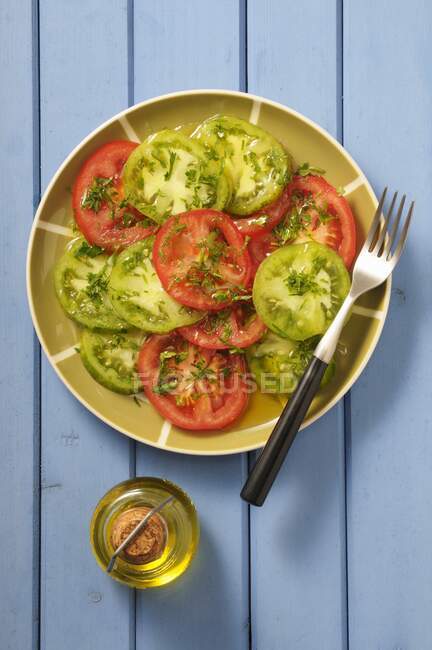 Red and green tomato carpaccio — Stock Photo