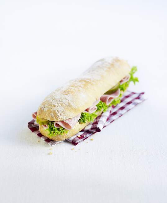 Un panino con prosciutto, lattuga e cetriolini sottaceto — Foto stock